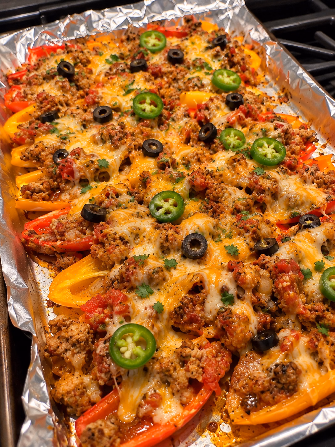 Mini bell pepper turkey nachos topped with melted cheese, black olives, jalapeño, and Greek yogurt.